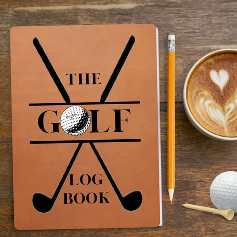 Gold log book with crossed golf club emblem and the word Golf written across the centre.  Tan, leather effect with pencil, golf tee and golf ball alongside a cup of coffee