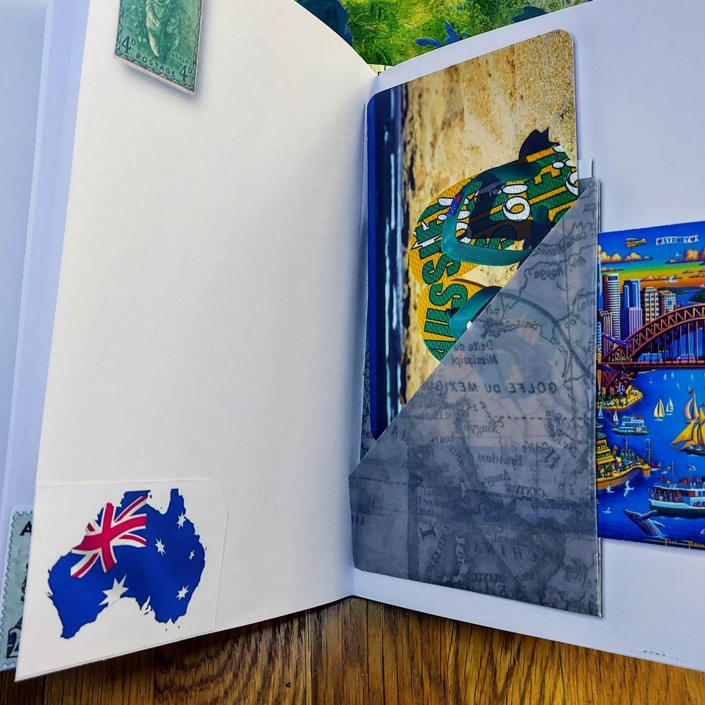 Open pages in Australia themed journal with multi-pocket and journaling cards. opposite page with koala stamp and Australia Flag as a map