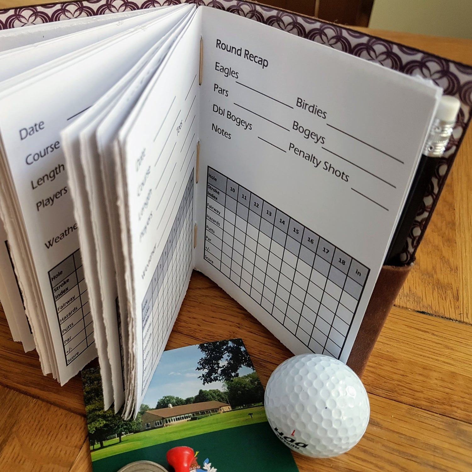 Handmade personalised golf log with grid of golf holes, golf ball and card