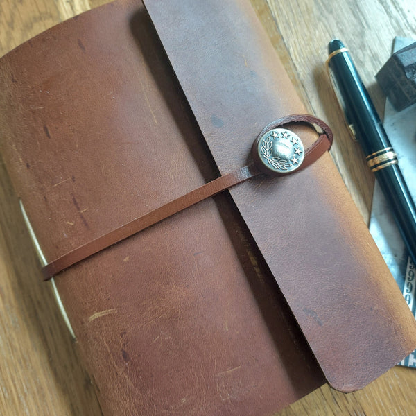 Rustic brown pull up leather trifold journal with metal button and leather strap