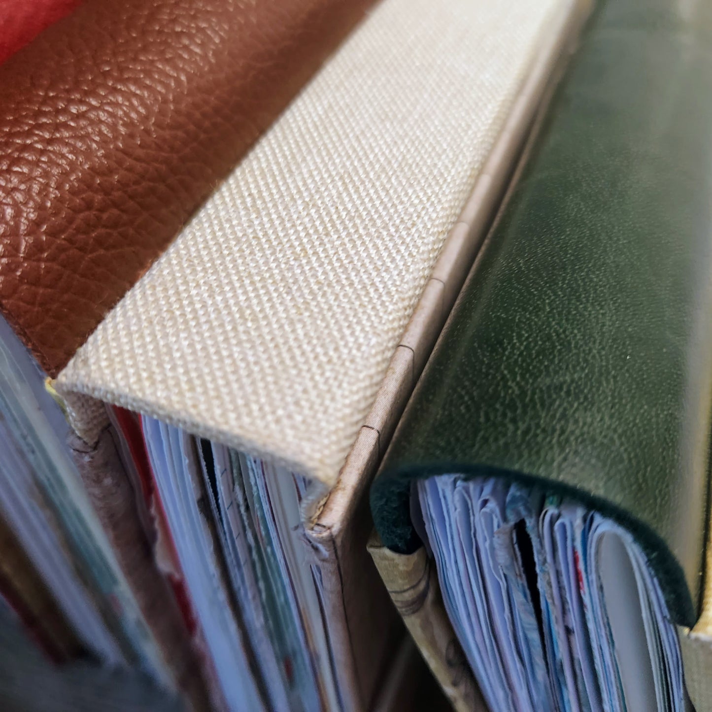 Close-up of a stack of books with leather and fabric covers.