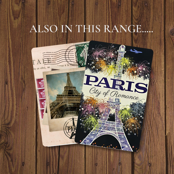 2 Paris travel planner journals on a table.  One has the Eiffel Tower, surrounded by fireworks with "City of Romance" under the title, the other has French postal images iwth an aged photo of the eiffel tower taken from the bottom, looking upwards