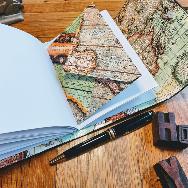 vintage map envelopes add interest to the rustic leather personalised travel journal