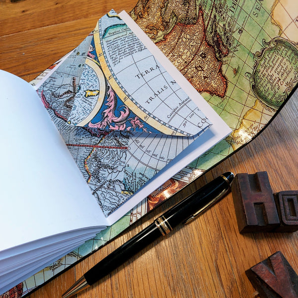 blue vintage map is used to make an envelope stitched into the personalised leather travel journal