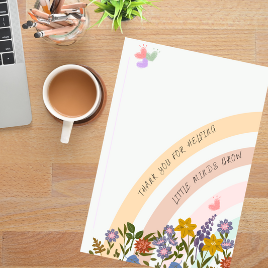 notebook with teaching inpirational message in rainbow bands with hearts and flowers