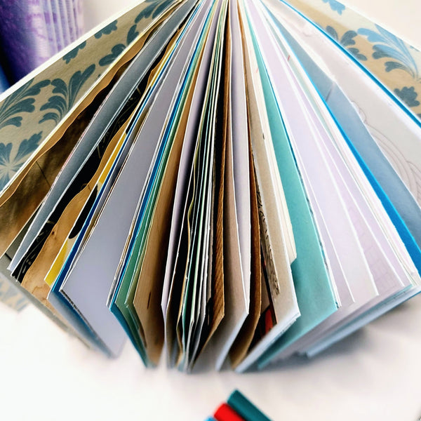 Mixed paper journal fanned out to show a variety of differnt papers making the pages