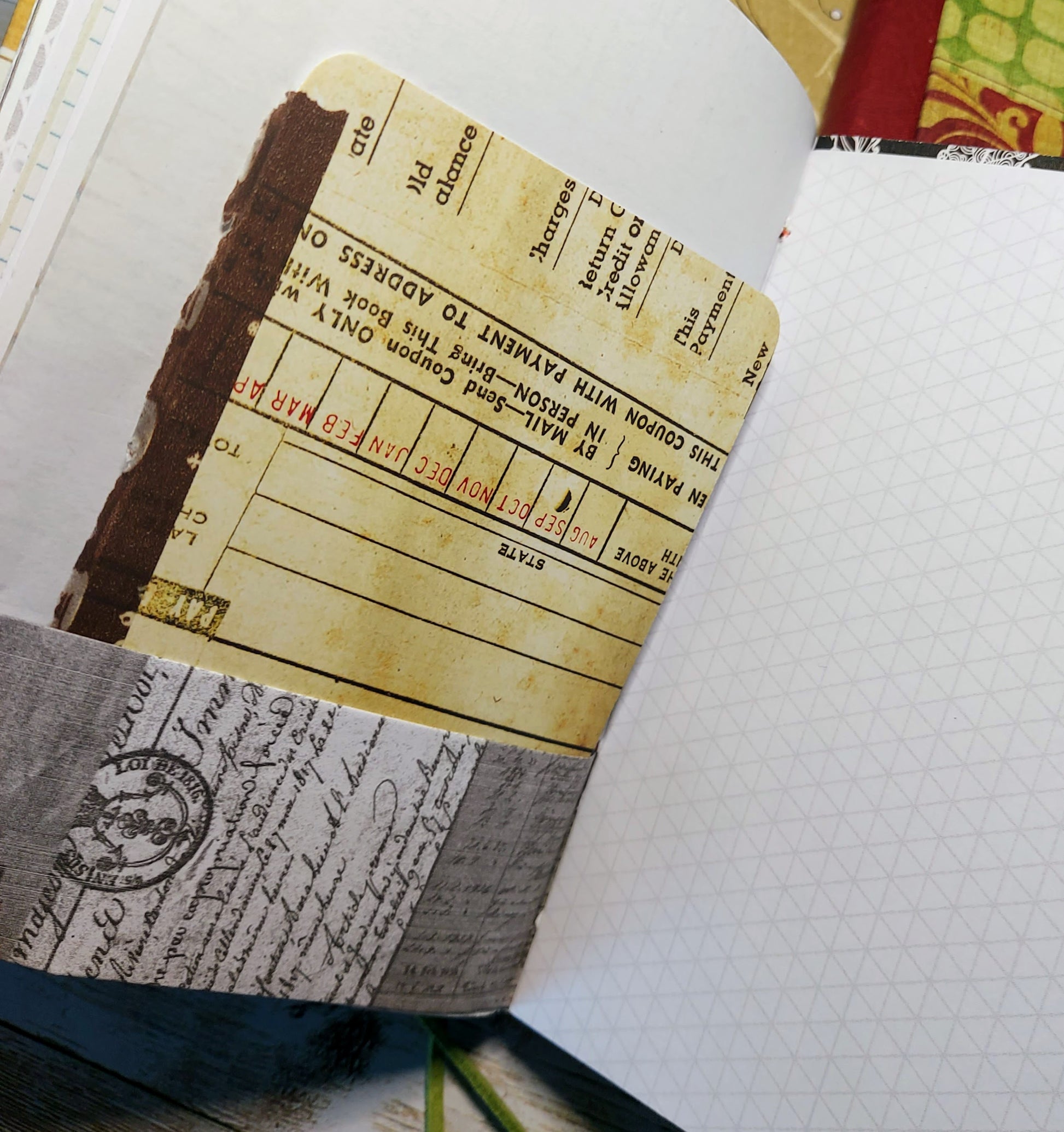 Close-up of a notebook with vintage-style pages and a yellowed paper insert.