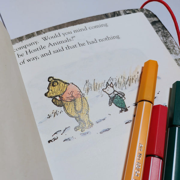 winnie the pooh illustration from a vintage book stitched into a mixed paper art journal notebook