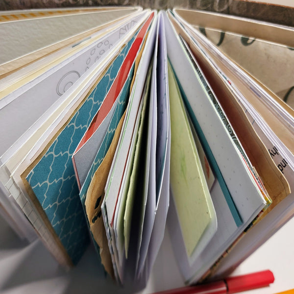 Mixed paper notebook fanned out to show a variety of papers