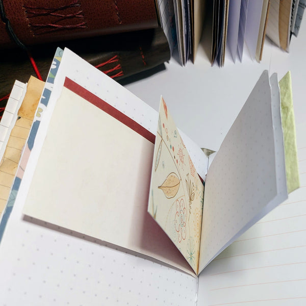smaller pages grouped together inside  a leather bound mixed paper journal notebook