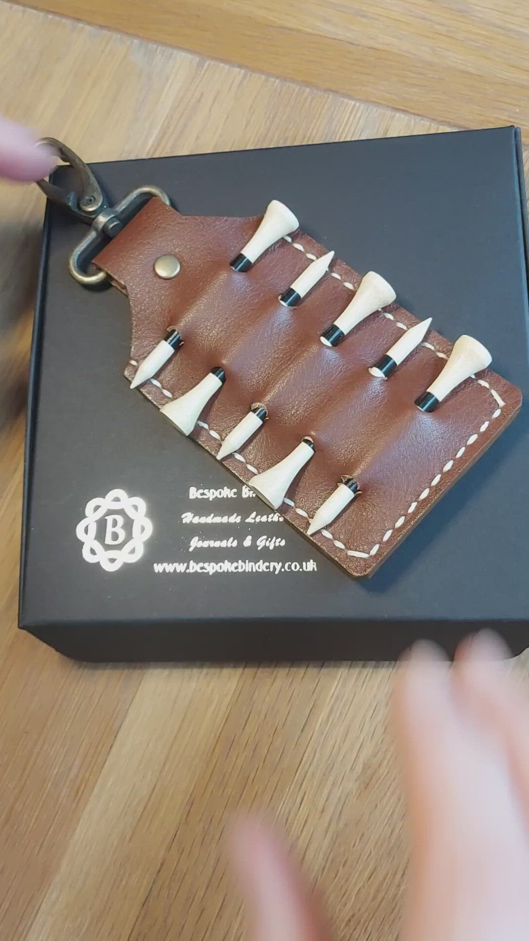 video showing brown personalised leather golf tee holder to clip on a golf bag