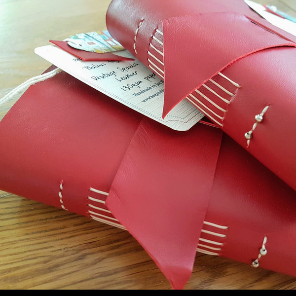 Red Leather bound travel journals with beaded spine by bespoke bindery