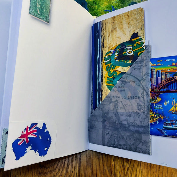 Open pages in Australia themed journal with multi-pocket and journaling cards.  opposite page with koala stamp and Australia Flag as a map