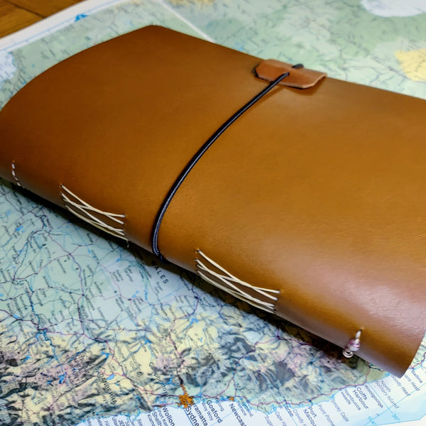 Australian theme A5 leather travel journal sitting on open Atlas map of Australia