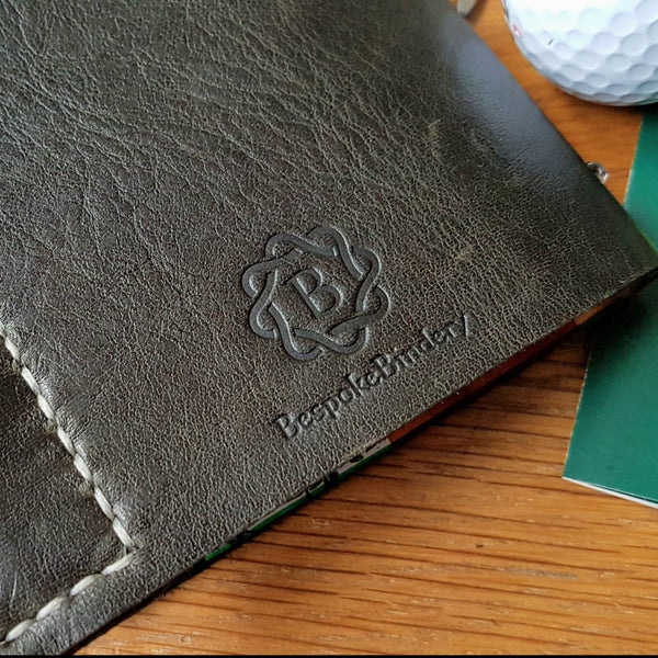 Men's golf score card log in darkest Green leather back cover showing Bespoke Bindery logo and handwtitched leather pencil pocket