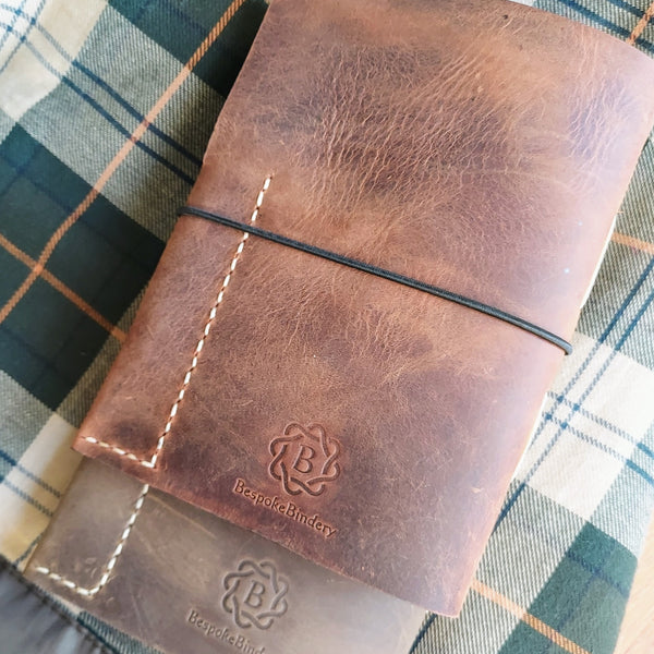 rustic brown or green coloured hand stitched leather hunting shooting journal in waxed leather