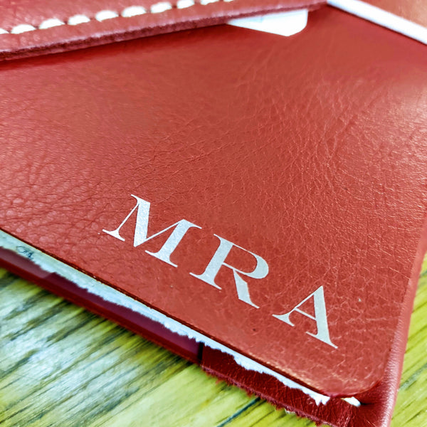 Gold initials personalising the front cover of red leather ladies golf journal