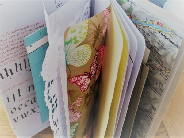 Mixed paper pages include calligraphy, lace doily, maps and other journaling and scrapbooking items