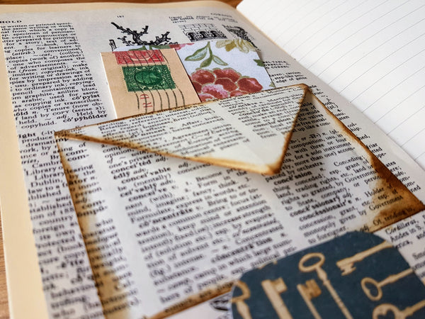 Handmade Junk Journal page with vintage dictionary envelope pocket and tags