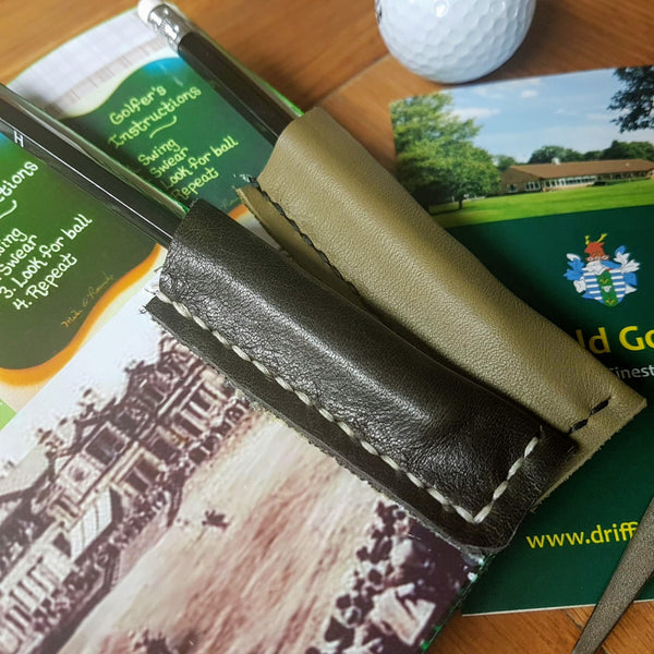 Pencil pockets inside the back cover of dark and olive green golf journals