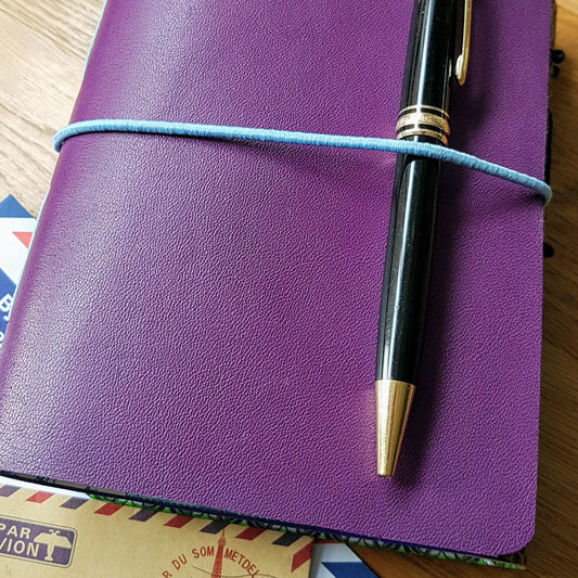Purple leather travel journal with pale blue elastic loop closure