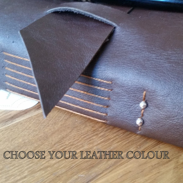 Leather travel journal with handstitched spine, decorative beads and wide strap